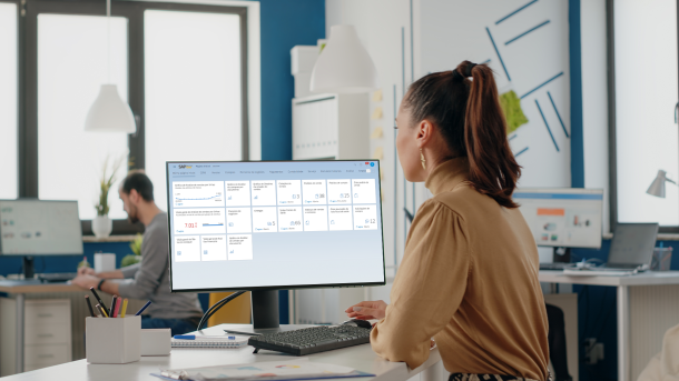 Mulher em um escritório olhando para uma tela na qual está o Web Client do SAP Business One