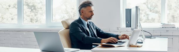 Homem mexendo no computador em um escritório