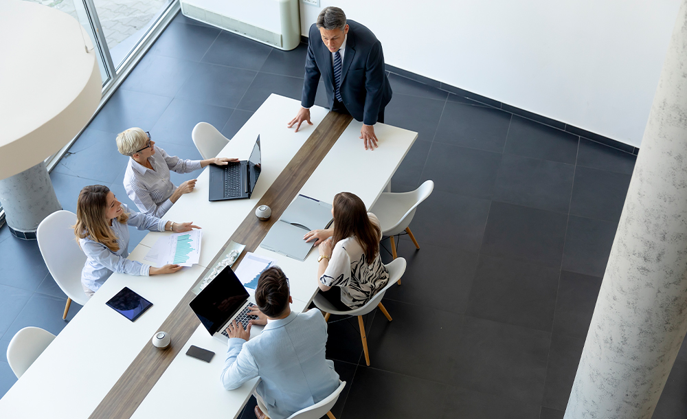 Pessoas em reunião, sentadas na mesa, em ambiente empresarial